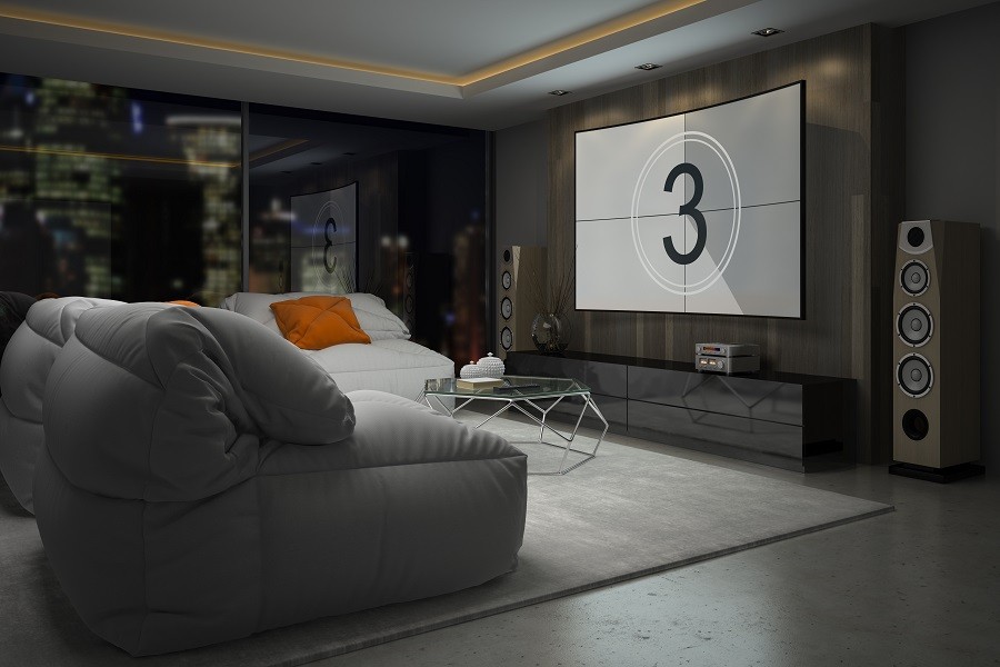 Modern and minimalist media room with home theater screen and speakers and comfortable and relaxed seating. 